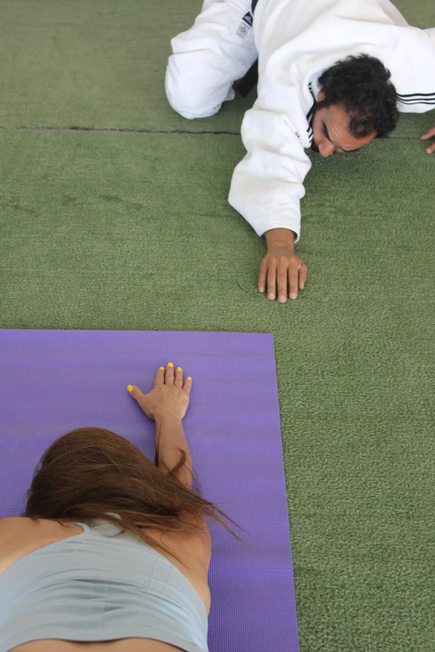 Manos apoyadas sobre el tatami durante un ejercicio de respiración